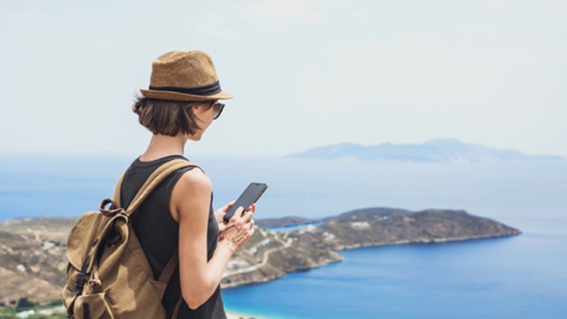 Woman with a phone in her hand near the sea