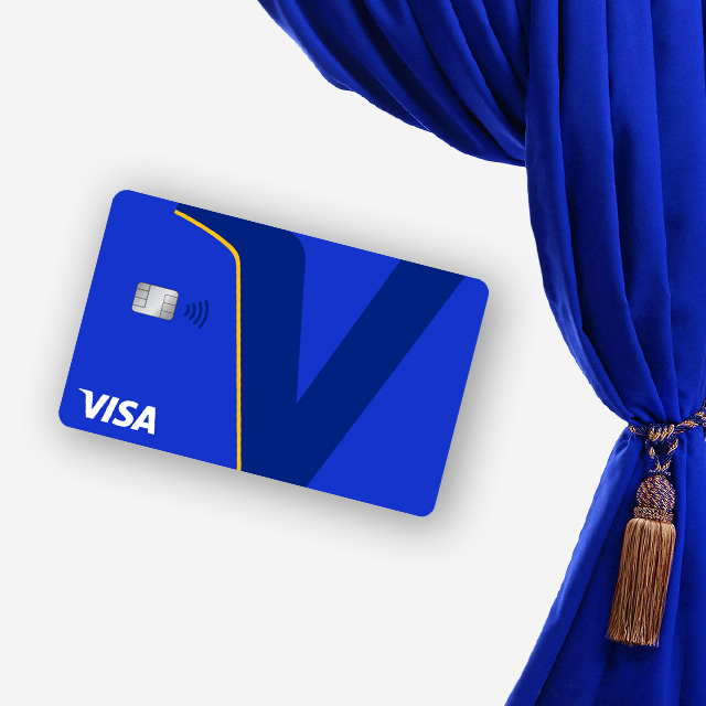 A blue Visa credit card with a large "V" design lies against an elegant, draped royal blue curtain. The tone is modern and sophisticated.