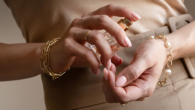 Perfume is sprayed on the wrist of a woman's hand