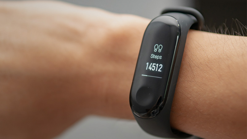 Sports watch on the wrist showing the number of steps taken