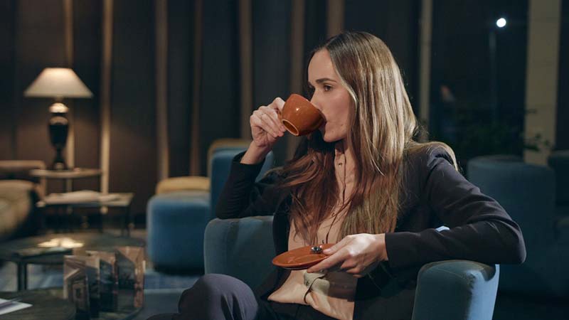 A woman drinking coffee in the lounge