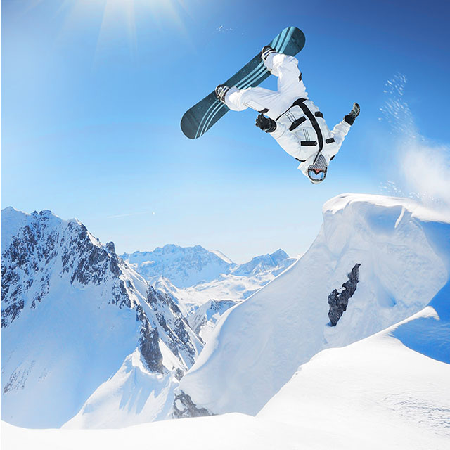 A person on a snowboard performs a trick in the air