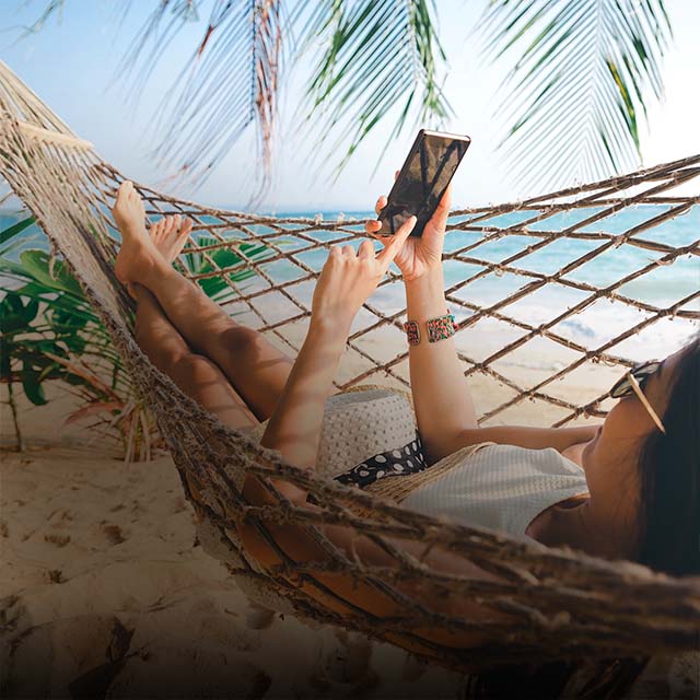 Woman resting in a hammock with a phone